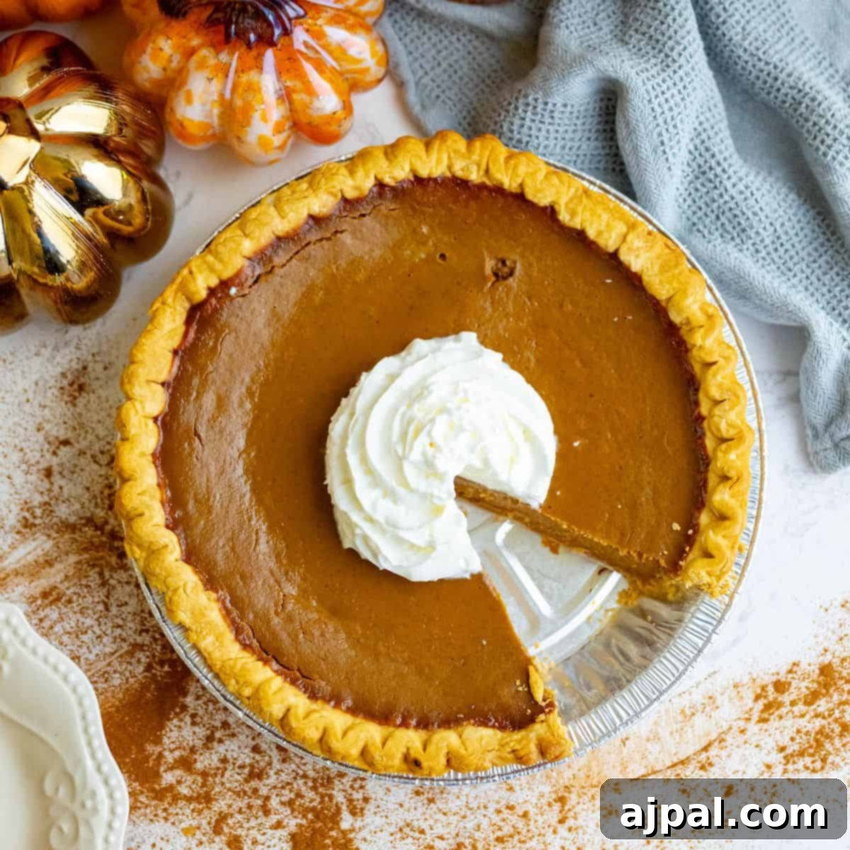 Spooktacular Halloween Treats You Need to Try 28 A spicy pumpkin pie with whipped cream and a slice taken out.