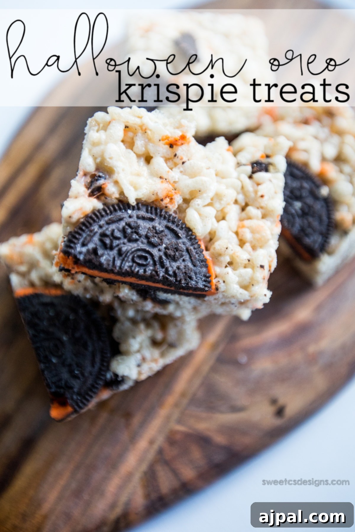 Delicious Halloween Oreo Krispie Treats with orange-filled Oreos, arranged on a wooden cutting board.