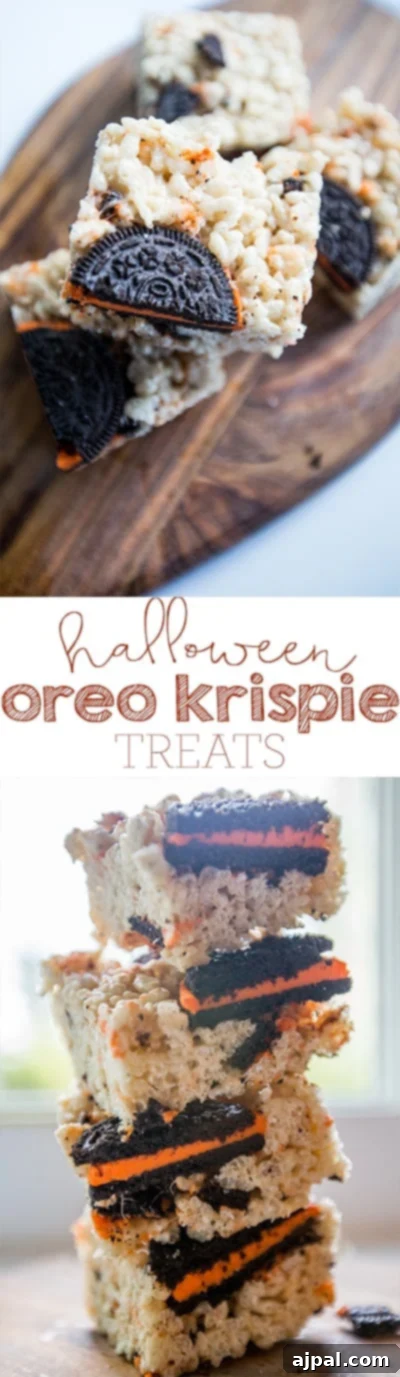 A stack of Halloween Oreo Krispie Treats on a wooden cutting board, highlighting their colorful layers and festive appeal.