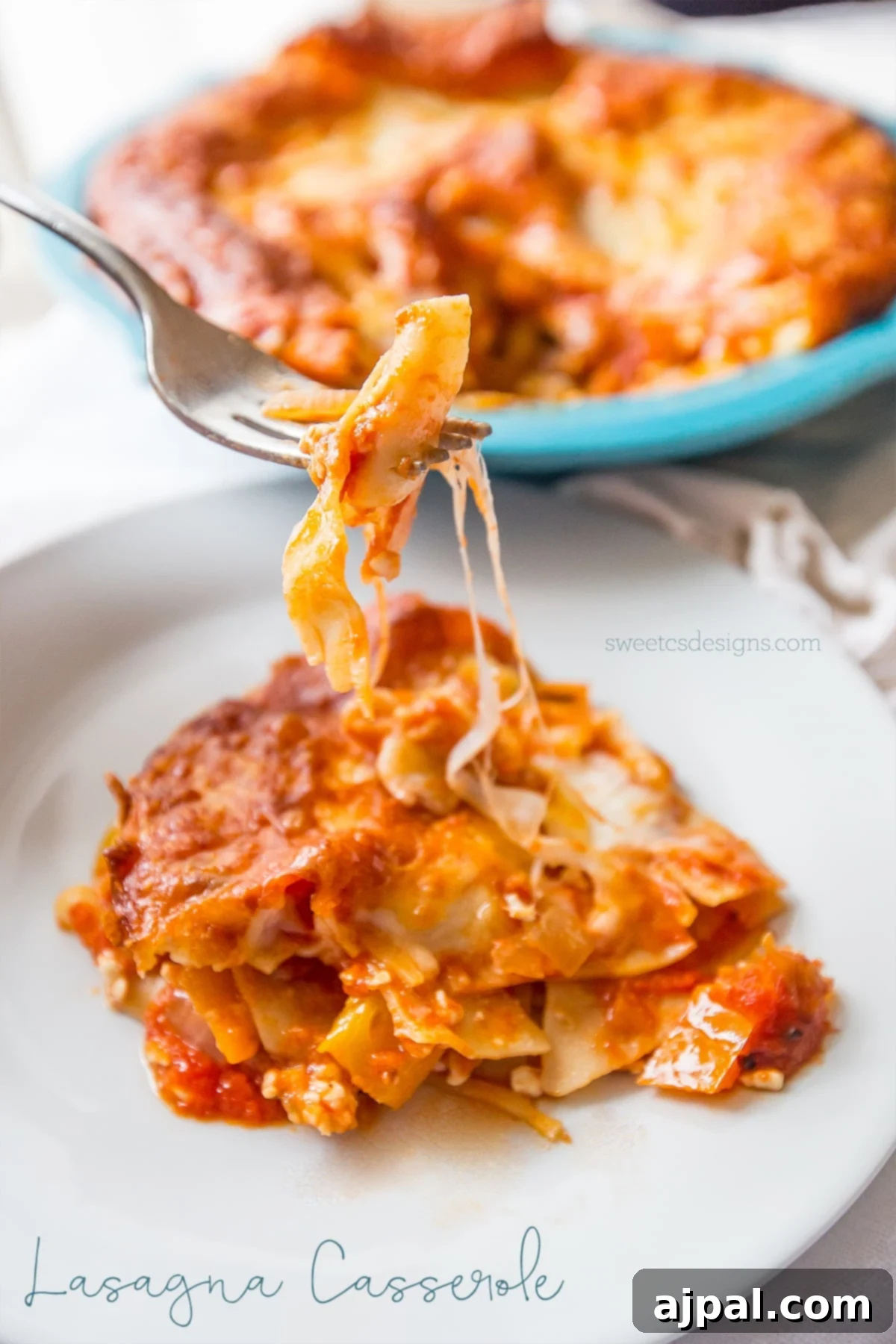 A fork lifts a savory portion of lasagna casserole, showcasing its perfectly layered noodles, rich sauce, and melted cheese, ready to be enjoyed.
