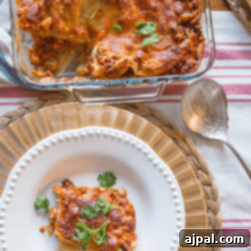 A plate of lasagna served with a spoon and fork.