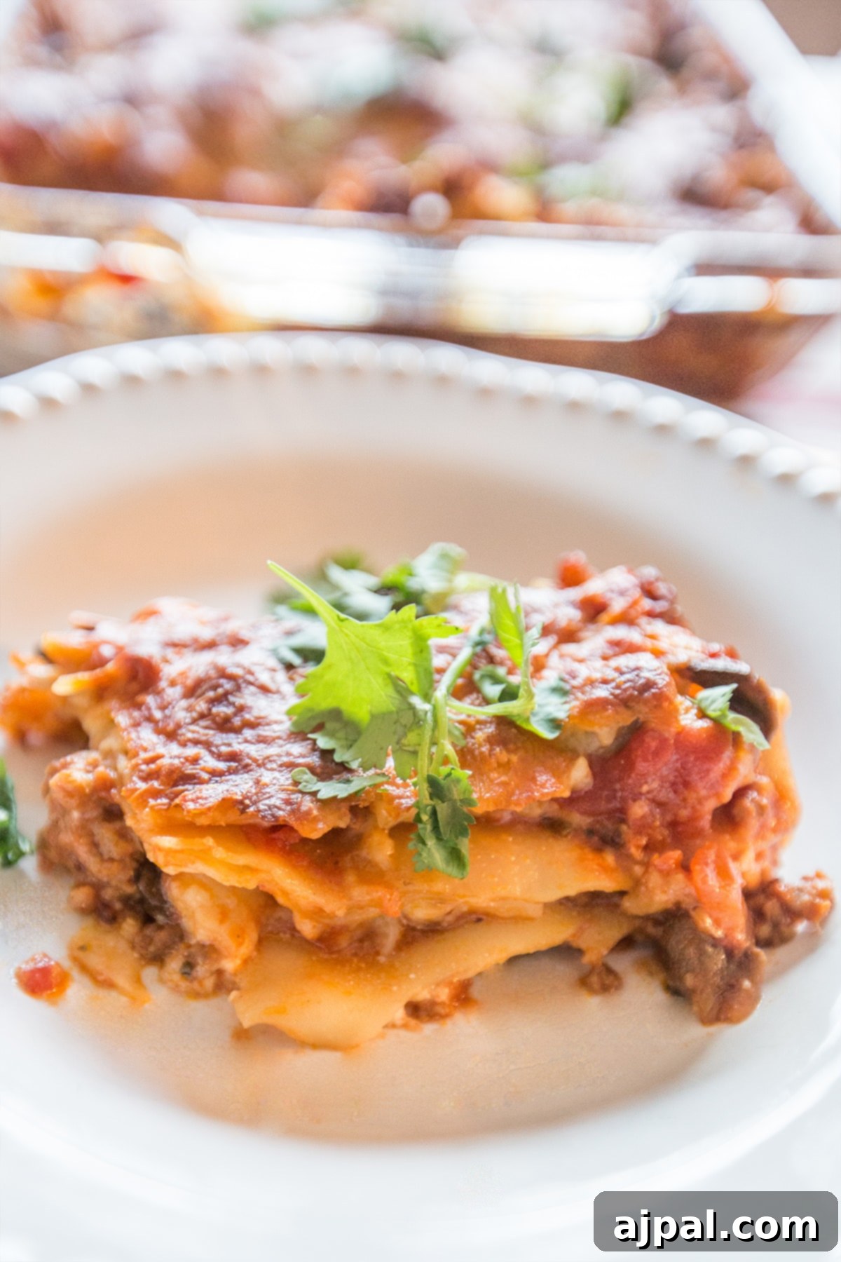 A serving of cottage cheese lasagna on a plate, garnished with fresh parsley