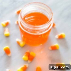 Candy corn jar infused with moonshine, vibrant orange hue.