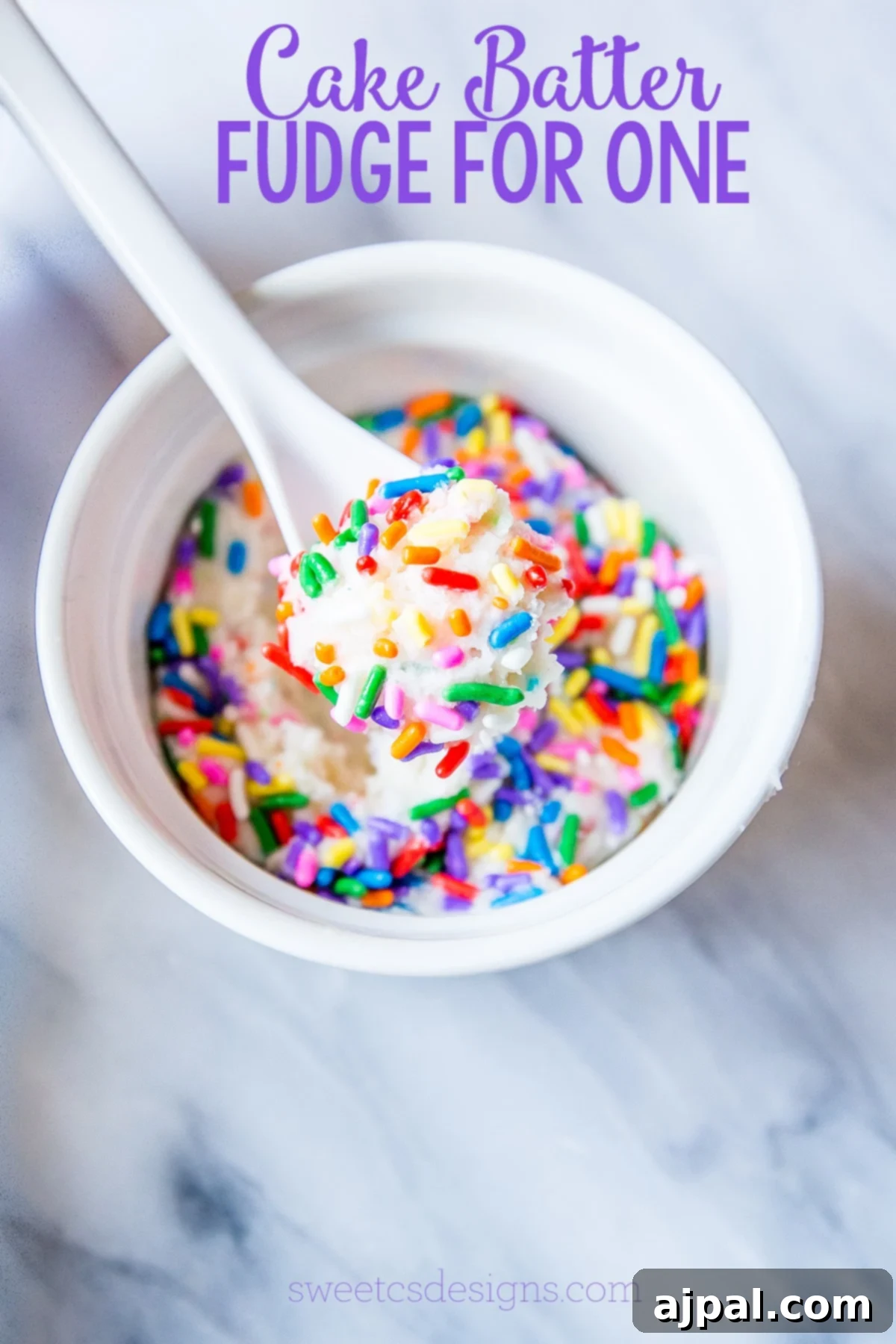 A bowl of white fudge with colorful sprinkles, accompanied by a spoon, highlighting the delicious single-serving cake batter fudge.