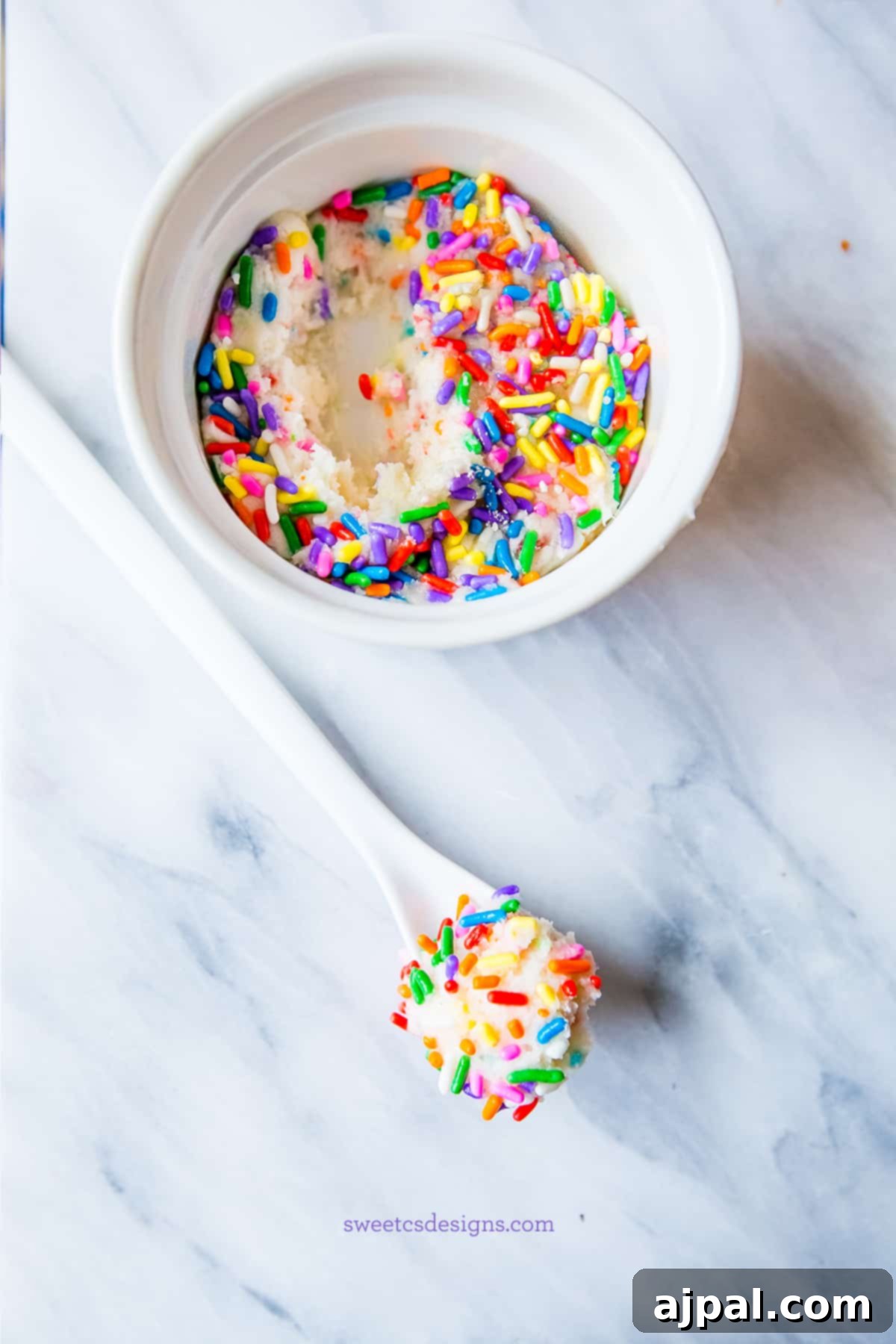 A delightful bowl of single-serving cake batter fudge with a spoon, highlighting its creamy texture and festive sprinkles.