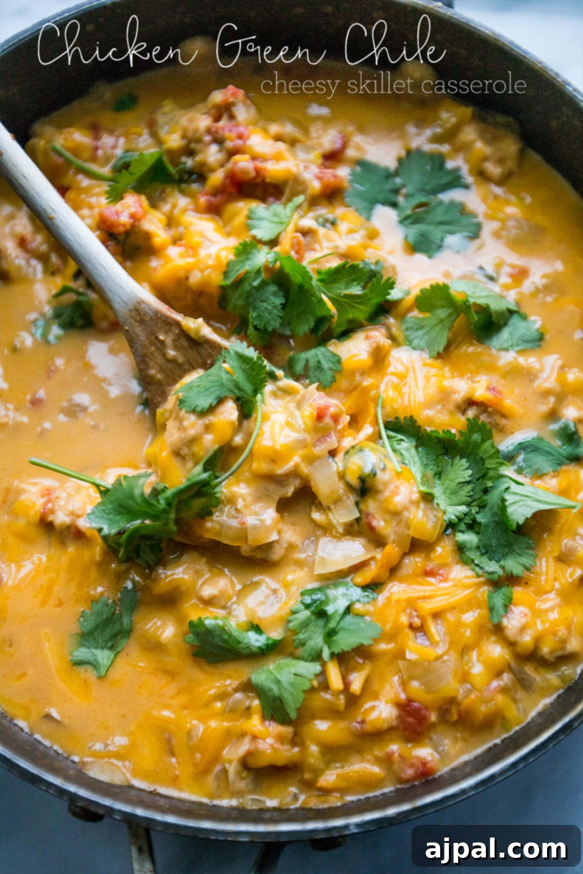 A vibrant, delicious Cheesy Chicken Green Chile Skillet, showcasing a medley of chicken, onions, bell peppers, tomatoes, and cilantro in a creamy, rich sauce, ready to be enjoyed.