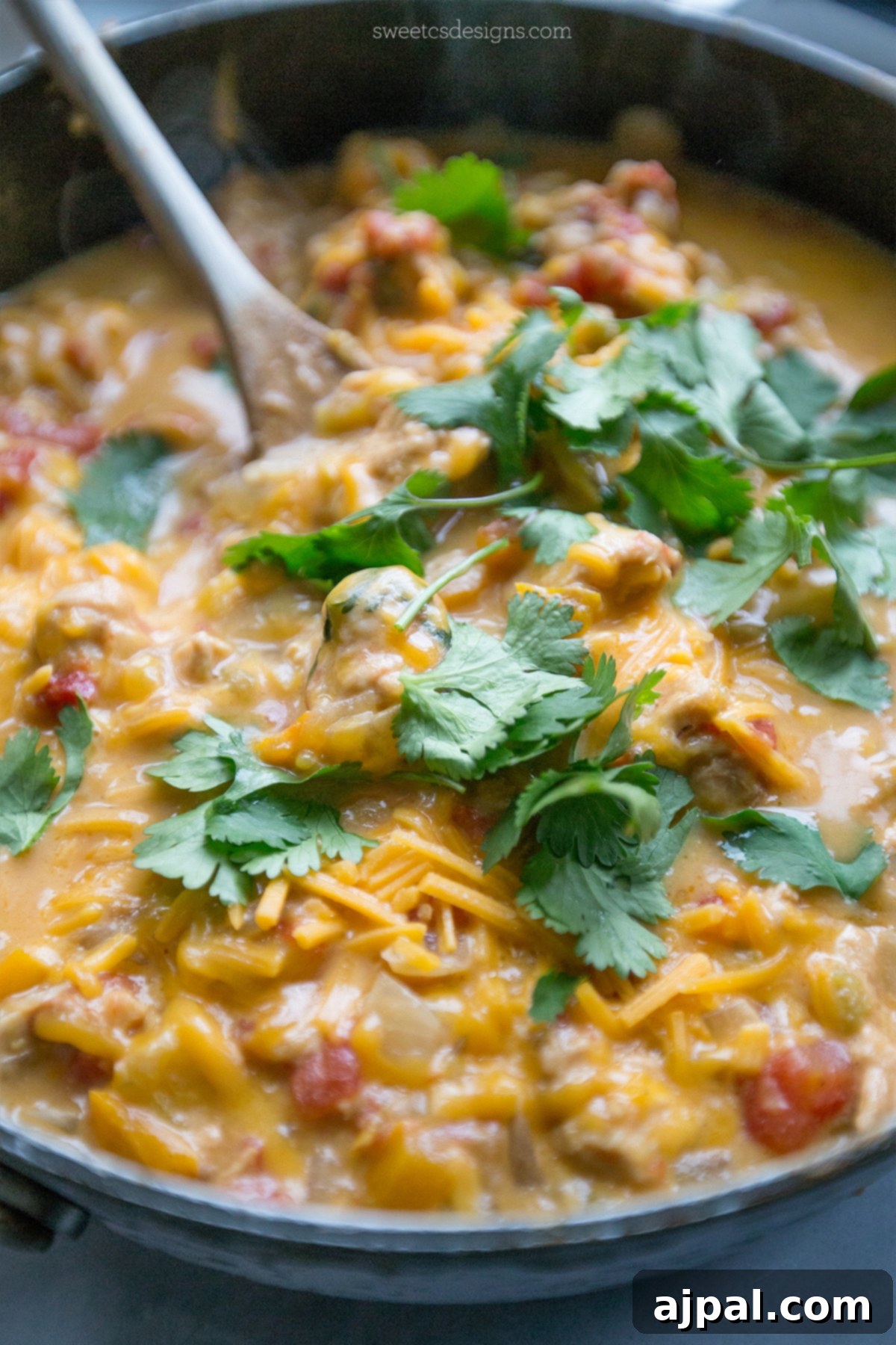 A large skillet brimming with One Pot Cheesy Chicken and Green Chile, showcasing the rich, creamy sauce, tender chicken pieces, and vibrant green chiles, ready to be served.