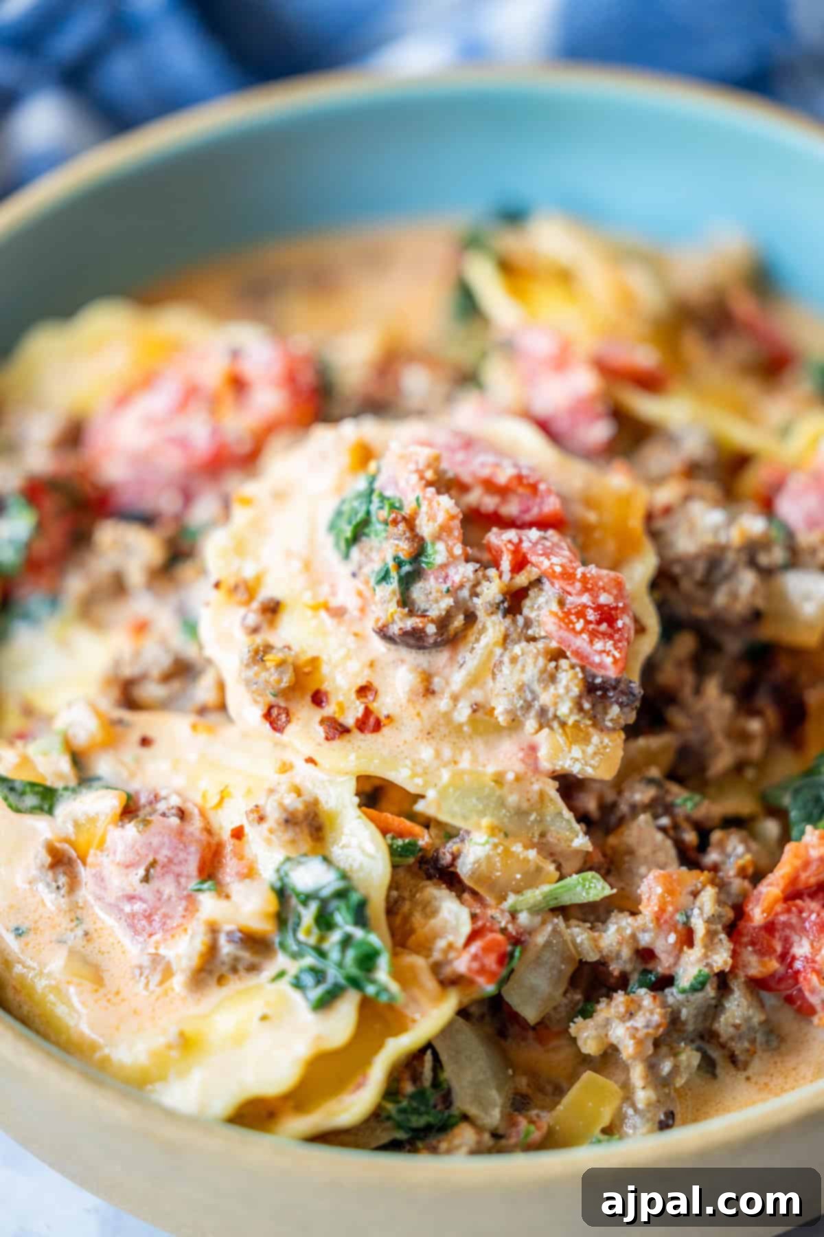 Creamy Tuscan Sausage Ravioli 12 Close-up of a bowl of creamy lasagna soup with ground meat, tomatoes, spinach, lasagna noodles, and a rich tomato spinach cream sauce—a comforting hearty meal.