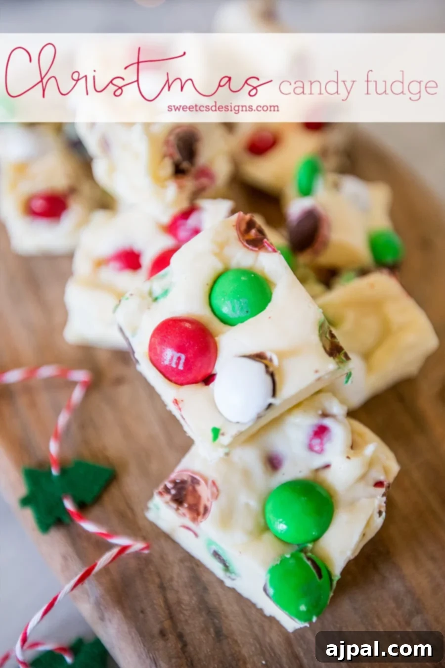 Festive Confectionery Fudge 2 Stacked pieces of vibrant Christmas candy fudge on a rustic wooden cutting board, showcasing its festive appeal and rich texture.