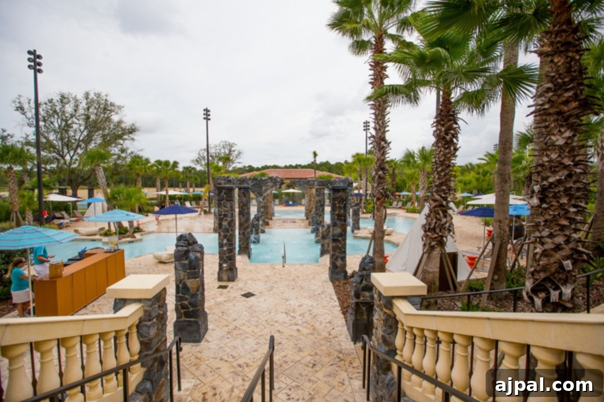 Four Seasons Orlando at Disney World A Magical Getaway 9 A view of the kids' pool and splash pad at The Four Seasons Orlando resort with palm trees.