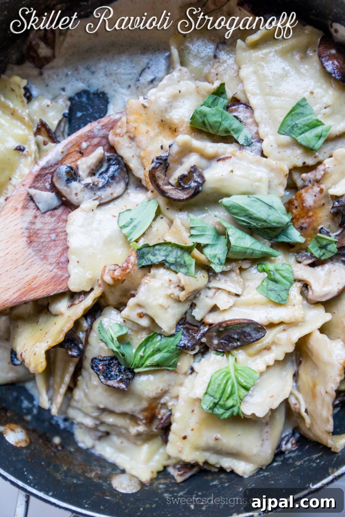 Close-up of Skillet Ravioli Stroganoff with mushrooms and fresh basil in a creamy sauce.