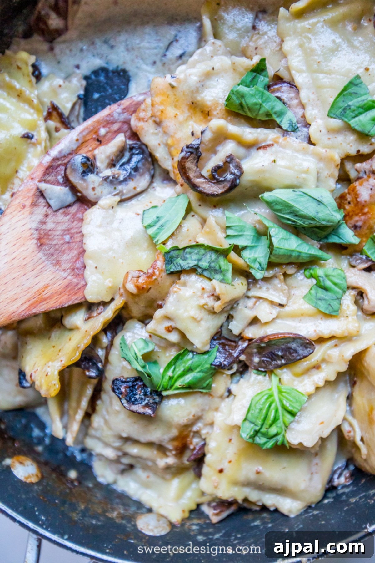 Serving Skillet Ravioli Stroganoff, a family favorite, garnished with fresh basil in a large bowl.