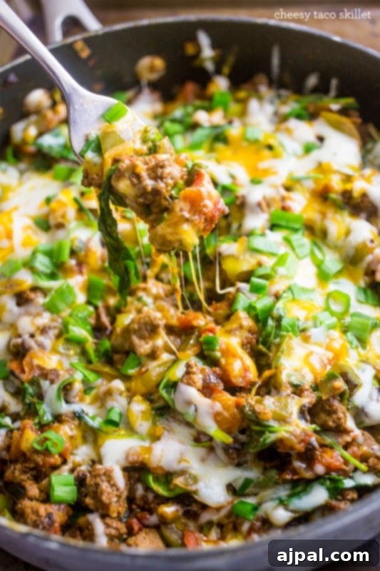 Cheesy Taco Skillet with a fork, a gluten-free and veggie-packed one-pan meal.