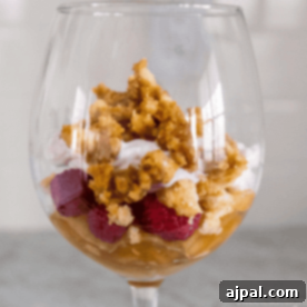 Enjoy a delightful Leftover Pie Parfait in a glass, featuring layers of luscious raspberries, fluffy whipped cream, and a crumbled topping that adds the perfect crunch.