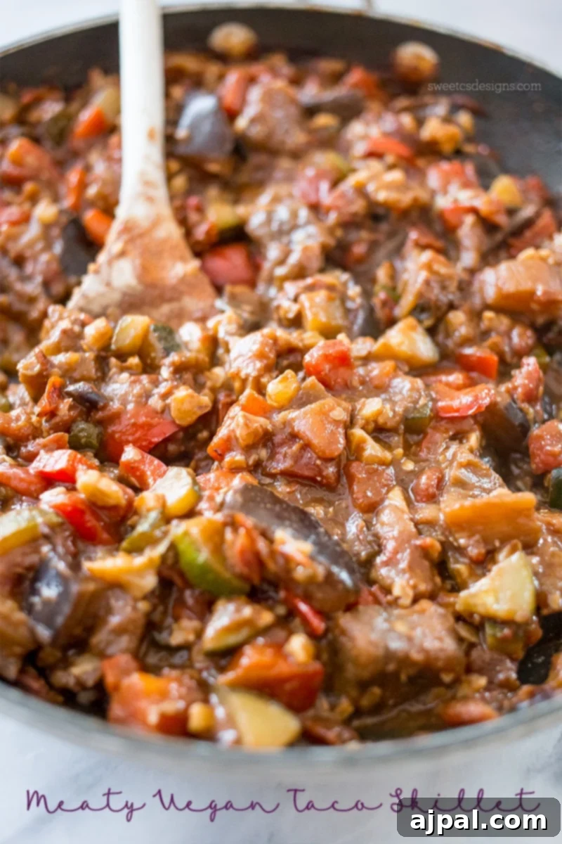 Hearty Paleo Vegan Taco Skillet 2 A vibrant skillet filled with sauteed vegetables like eggplant, zucchini, tomatoes, and chickpeas, resembling a hearty vegan taco filling.