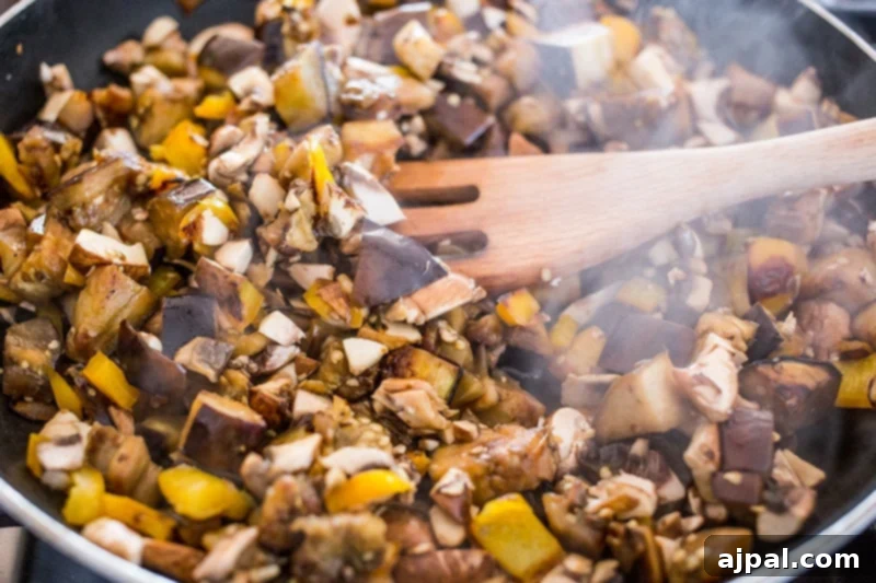Hearty Paleo Vegan Taco Skillet 6 Close-up of mushrooms and other vegetables sizzling in a pan, preparing a rich base for a vegan taco skillet.