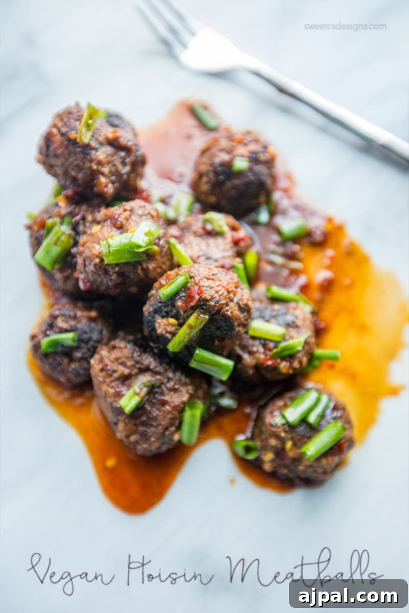 Sticky Vegan Hoisin Meatballs 5 Plated Vegan Hoisin Meatballs with a rich sauce and green onion garnish.