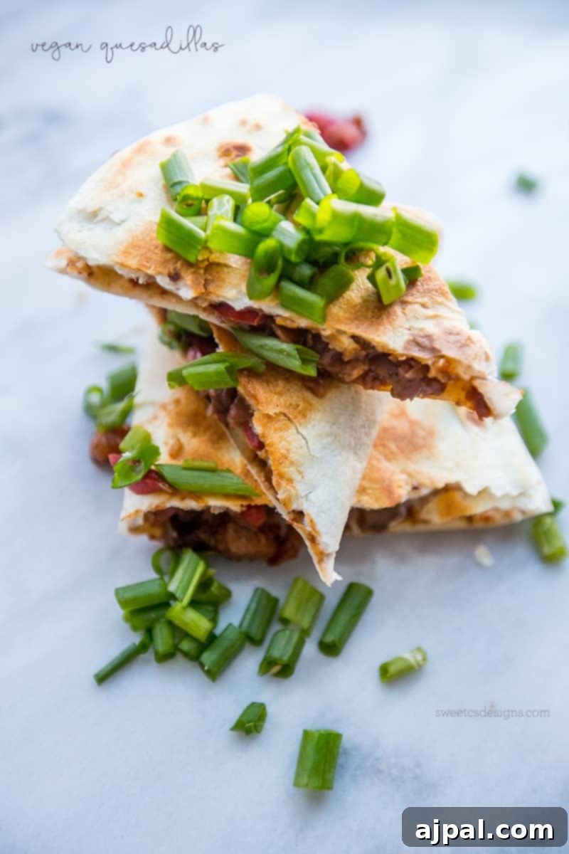 A beautiful stack of vibrant vegan quesadillas, garnished with fresh green onions, inviting you to enjoy a delightful plant-based meal that's both hearty and healthy.