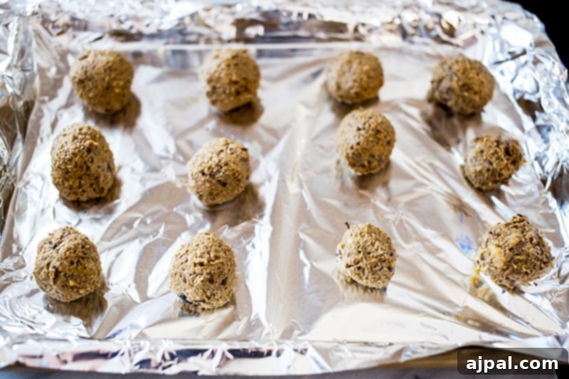 Smoky Vegan Paleo BBQ Meatballs 6 Paleo vegan meatballs expertly formed and arranged on parchment paper, ready for baking.