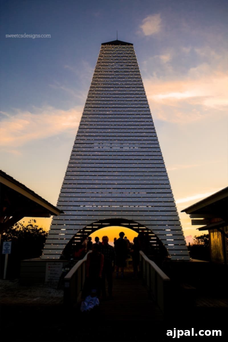 Yuletide in Paradise Seaside Florida 11 The clock tower in Seaside Florida beautifully lit up at Christmas sunset, with people gathering nearby.