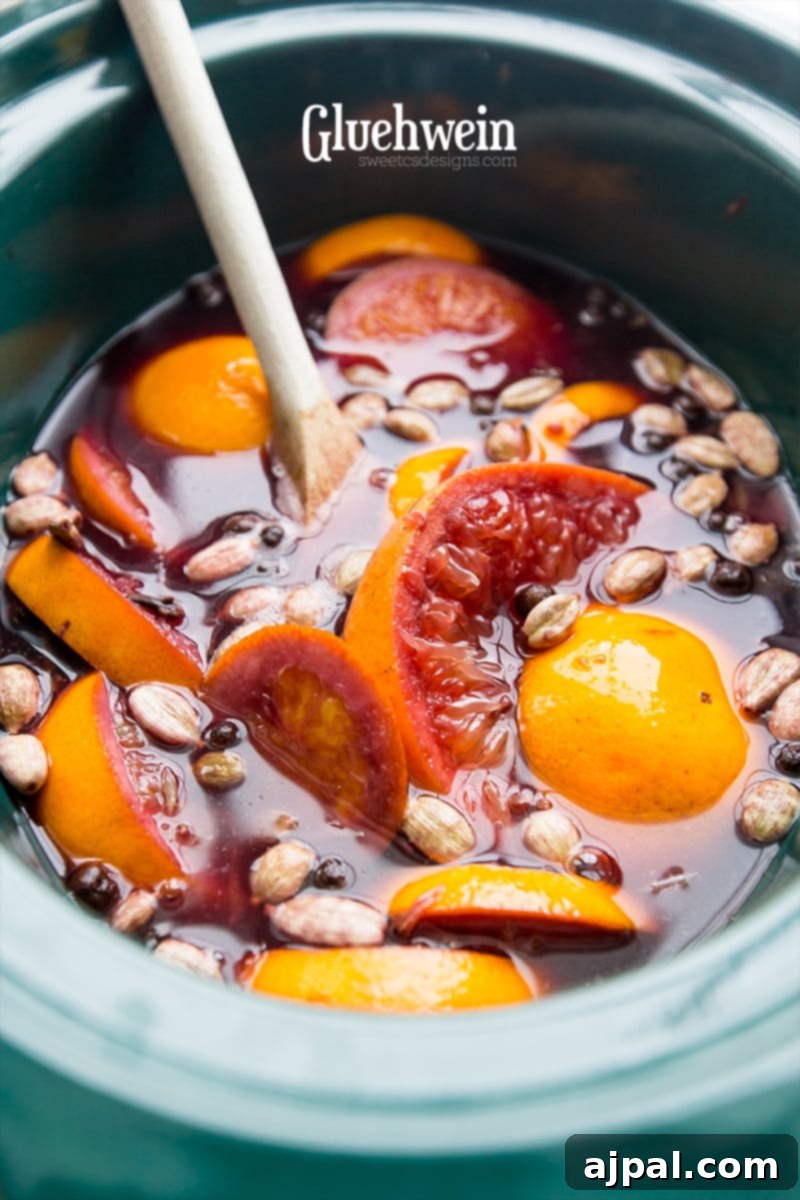 Spiced Winter Warmer 5 A slow cooker filled with steaming traditional Glühwein, garnished with orange slices, cinnamon sticks, and star anise, ready to be served at a festive holiday gathering.