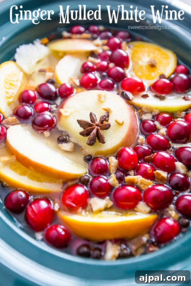 Liquid with orange slices, apple slices, cloves, and cinnamon sticks, showcasing the rich, spiced blend.