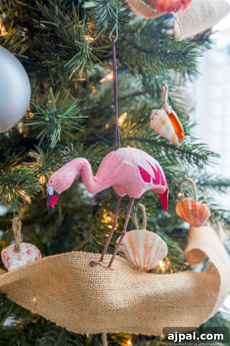 Easy Seashell Tree Decorations for a Coastal Vibe 4 An adorable pink flamingo ornament, intricately designed, perches elegantly on a seashell tree ornament, adding a touch of whimsy to the beach-themed Christmas tree.