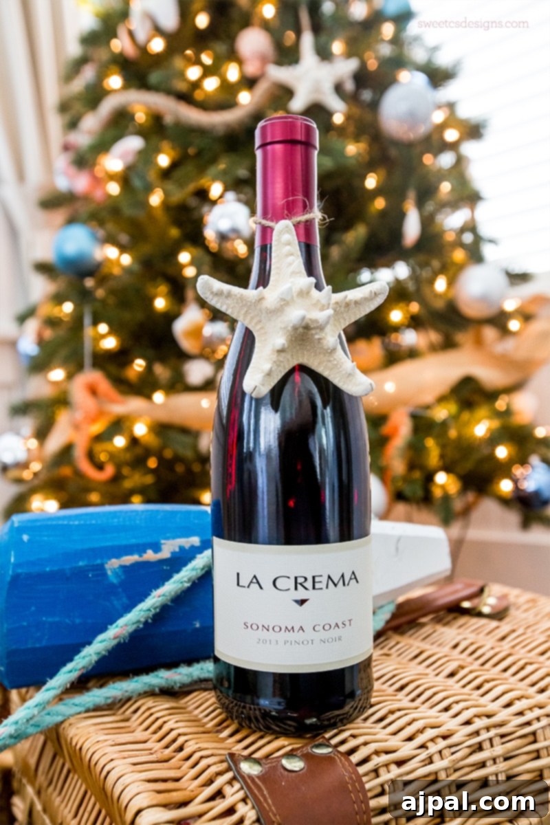 Easy Seashell Tree Decorations for a Coastal Vibe 9 Elegant starfish ornament charms tied to a bottle of wine, presented on a wicker basket in front of a beautifully decorated Beach Themed Tree, perfect for a coastal holiday gift.