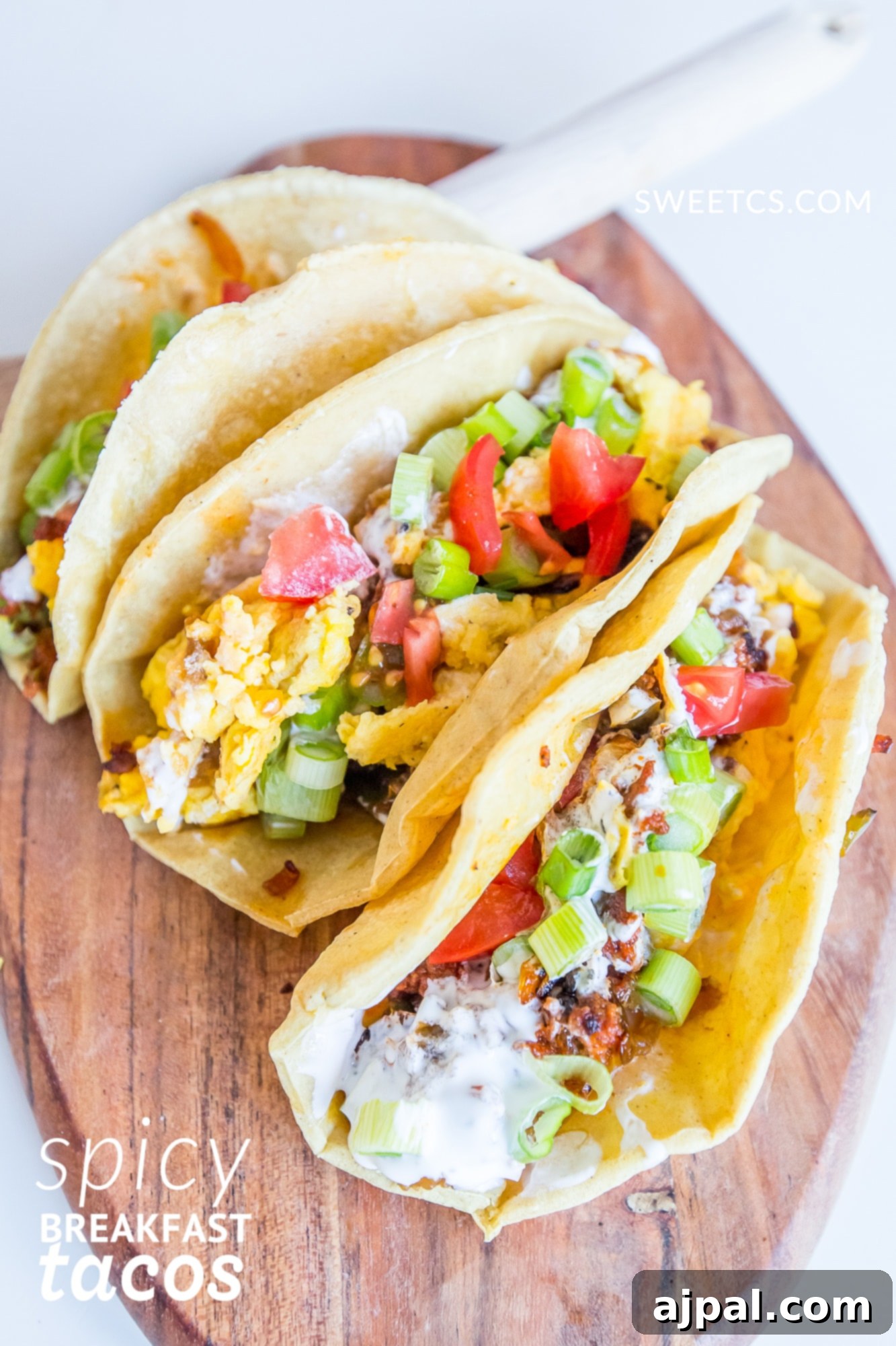 Close-up of freshly prepared spicy egg and chorizo breakfast tacos on a wooden board, ready to be enjoyed.