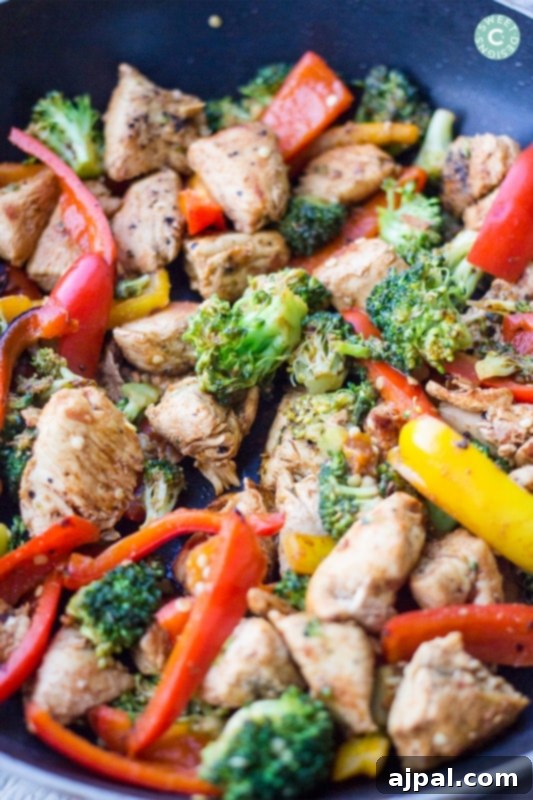 chicken with peppers and broccoli in a bowl with sauce