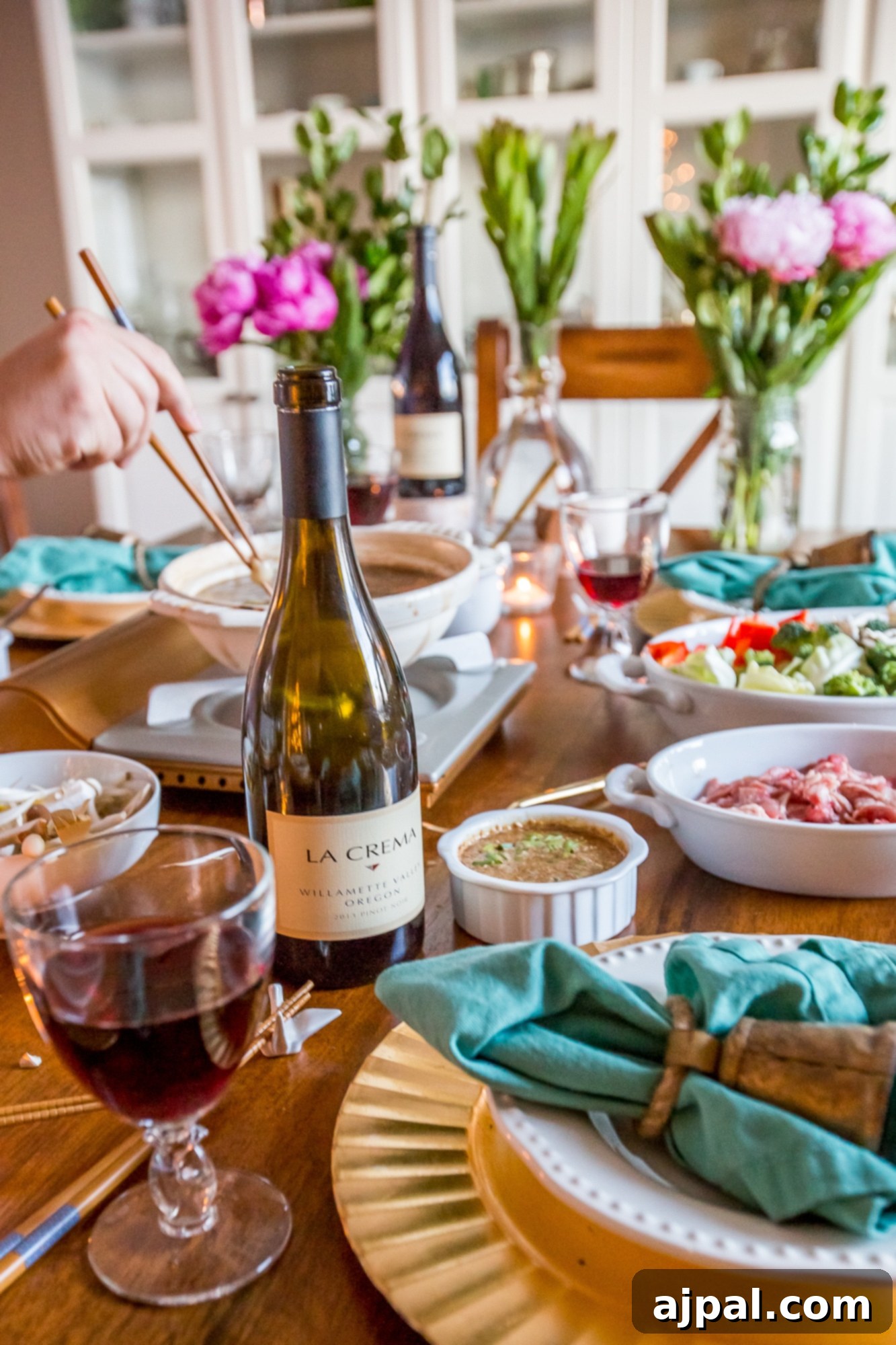 A beautifully set table for an Asian dinner, featuring a bowl of sesame dipping sauce and elegant chopsticks.
