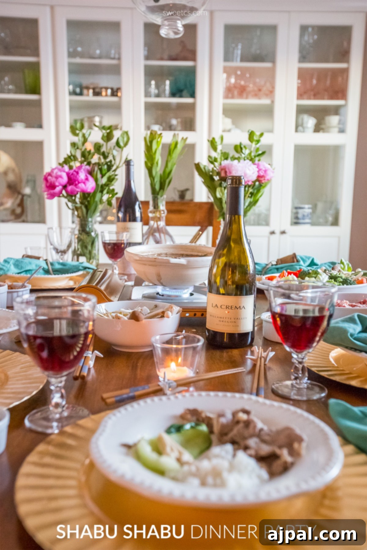 A festive table beautifully set for a shabu shabu dinner party, showcasing a hot pot and various fresh ingredients.