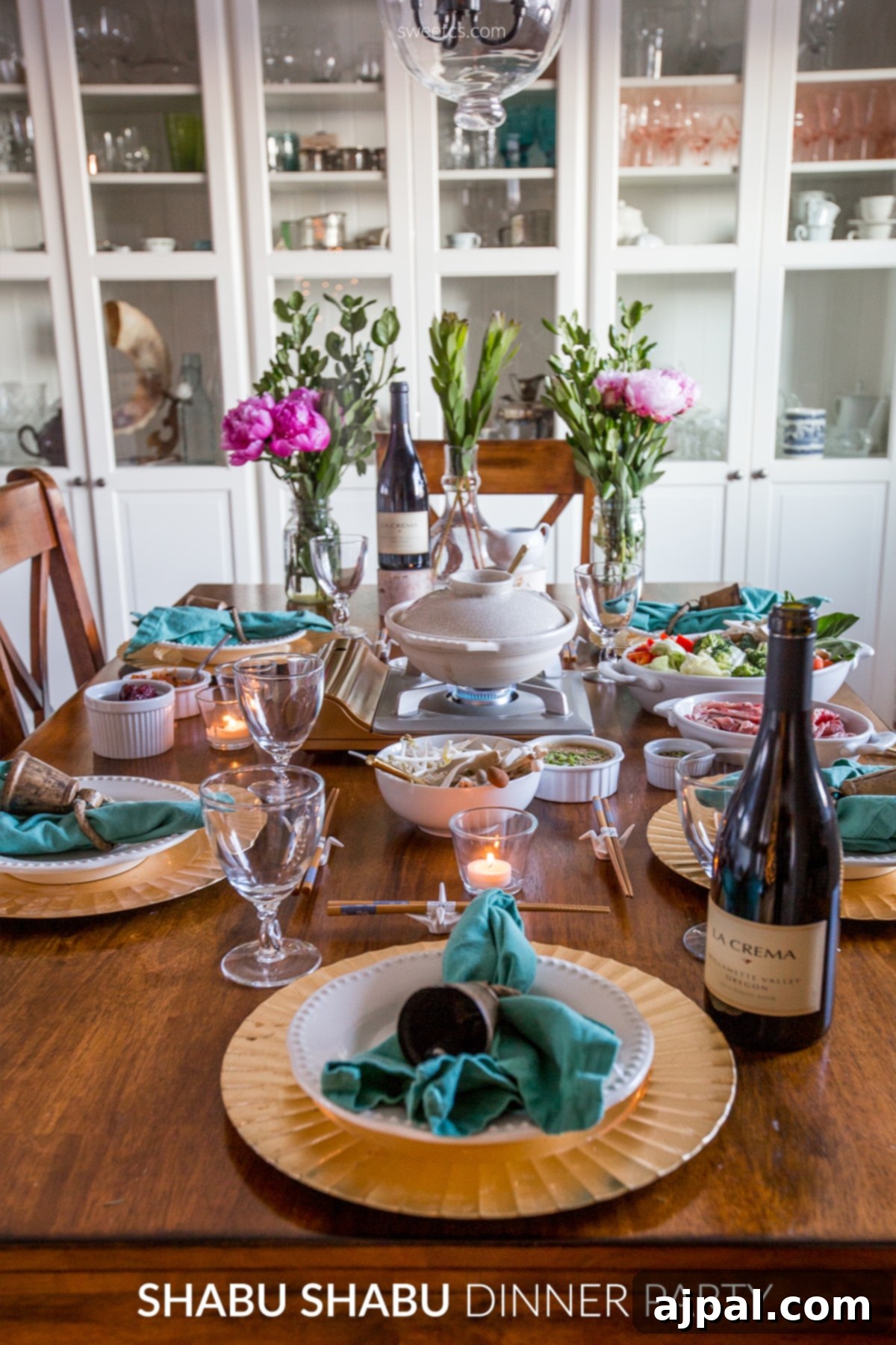 A beautifully arranged table for a shabu shabu dinner party, with a hot pot and an array of fresh ingredients for dipping.