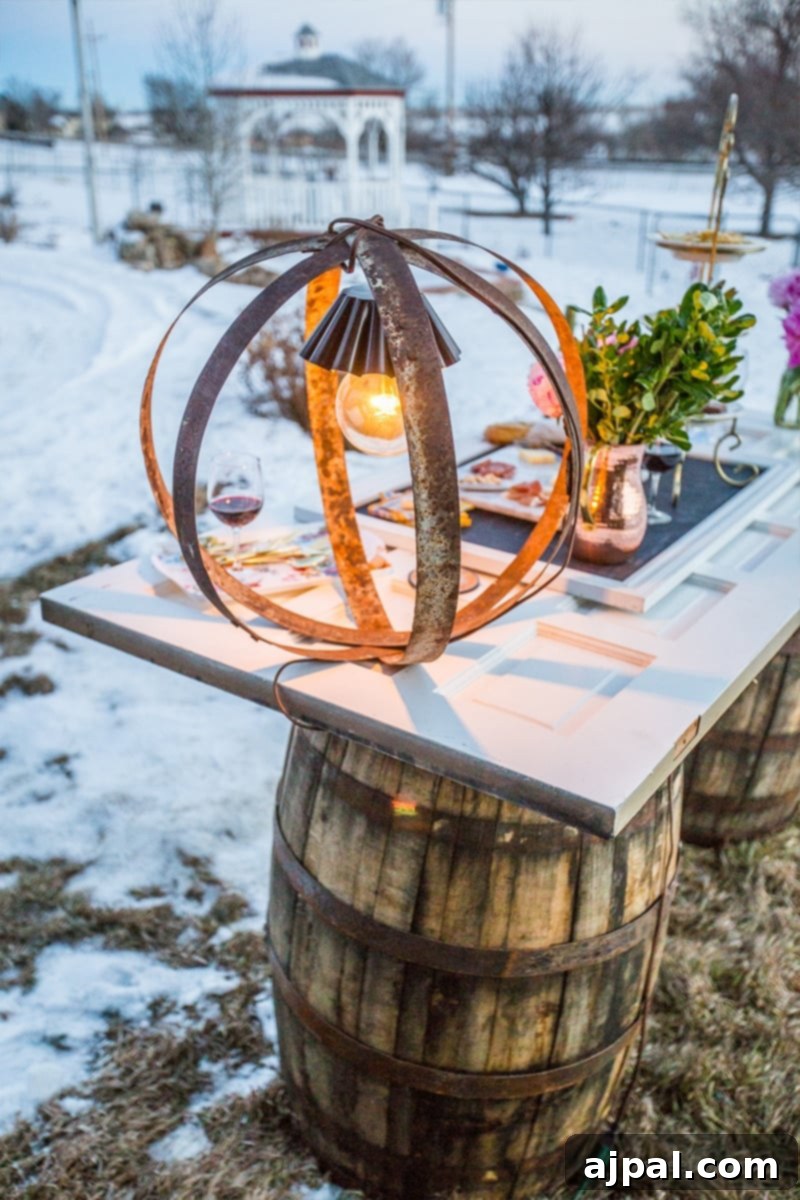 Upcycled Wine Barrel Ring Chandelier 2 A stunning rustic wine barrel ring light illuminates an outdoor setting on a snowy evening, showcasing its warm glow amidst natural elements.