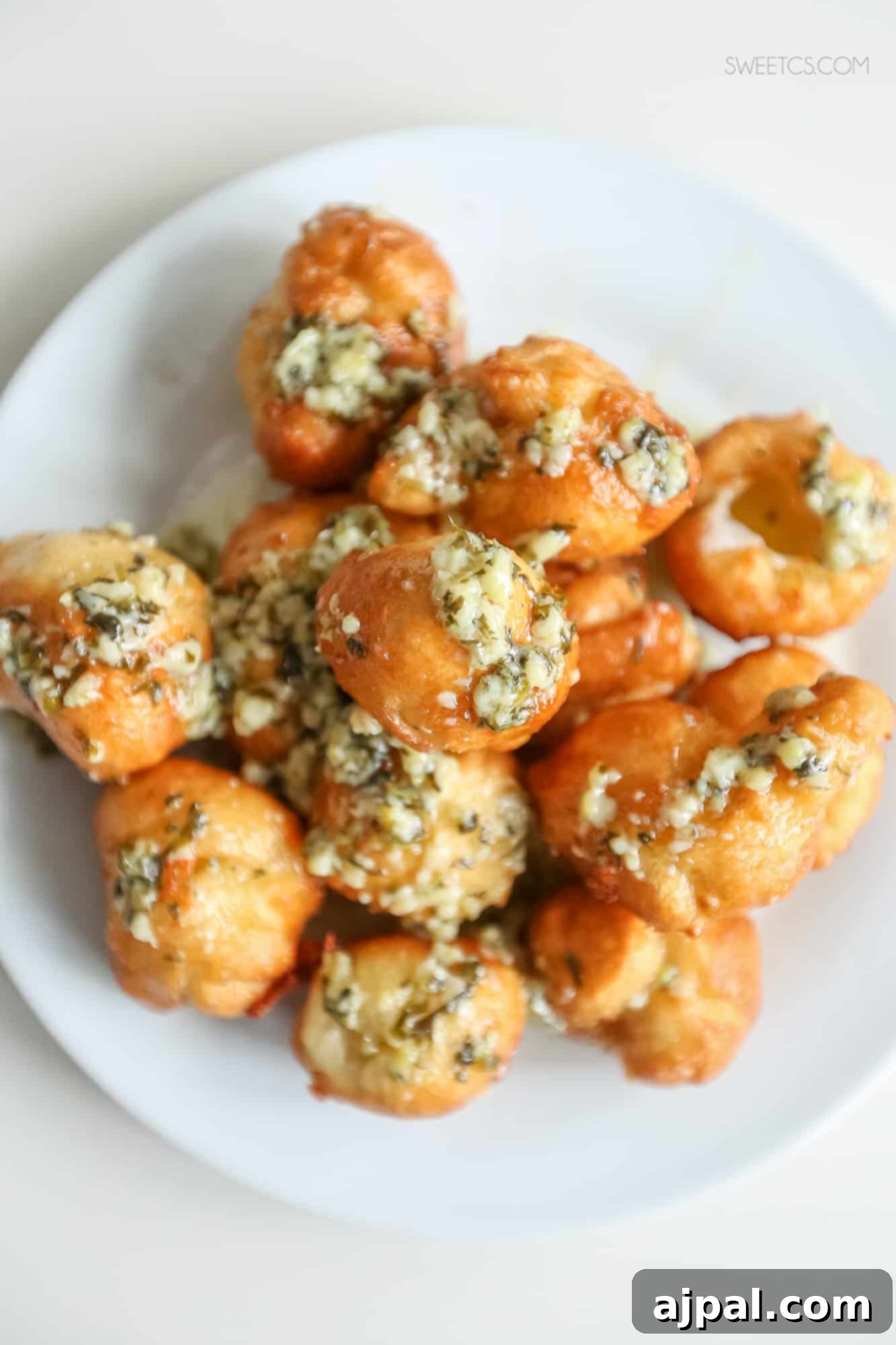 Crispy Garlic Cheese Blasts 6 Close-up of golden fried garlic cheese bombs on a white plate, incredibly appetizing.