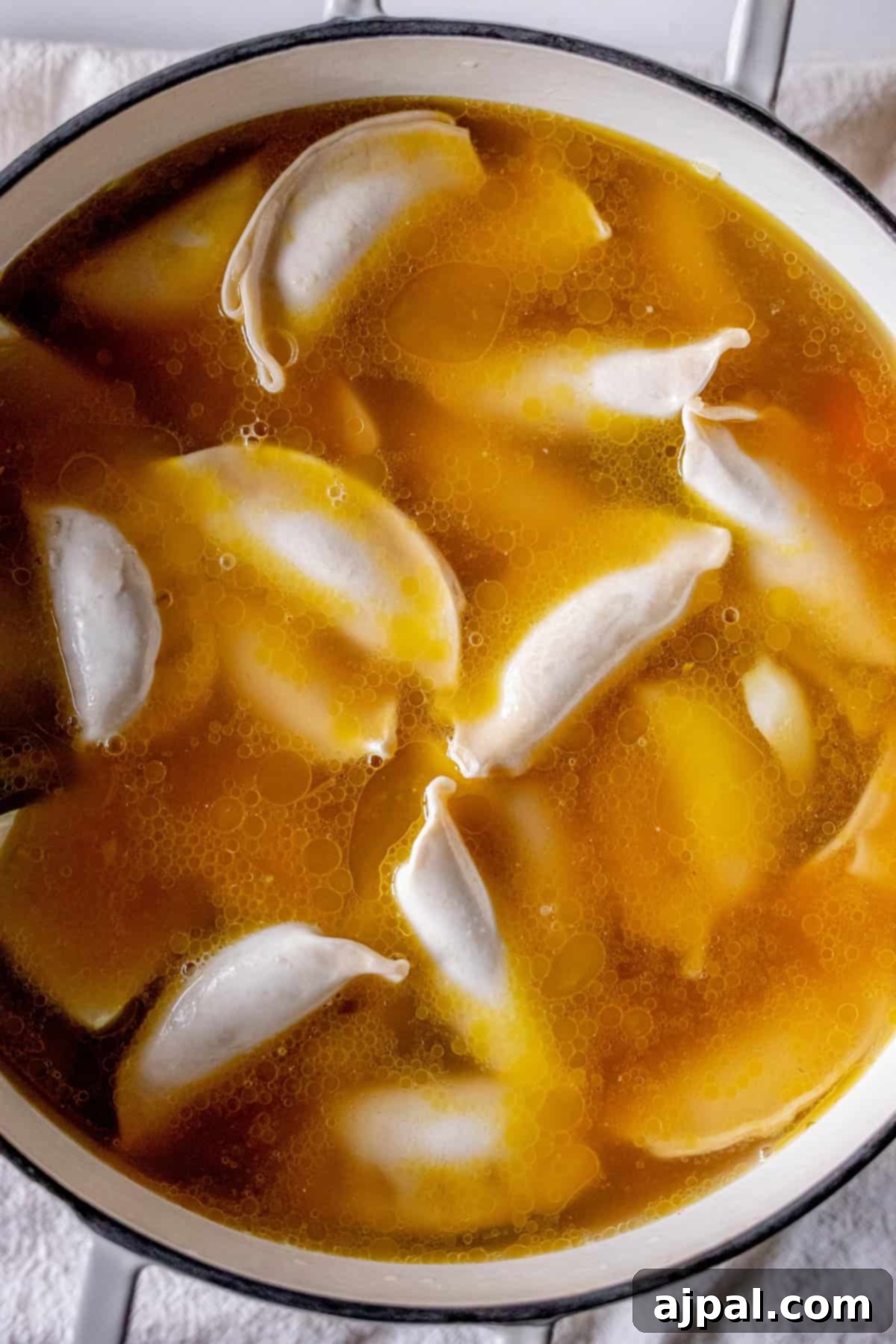 Easy 15-Minute One-Pot Potsticker Soup 11 A pot of dumplings simmering in golden broth on the stovetop, transforming into a delightful 15 minute potsticker soup.