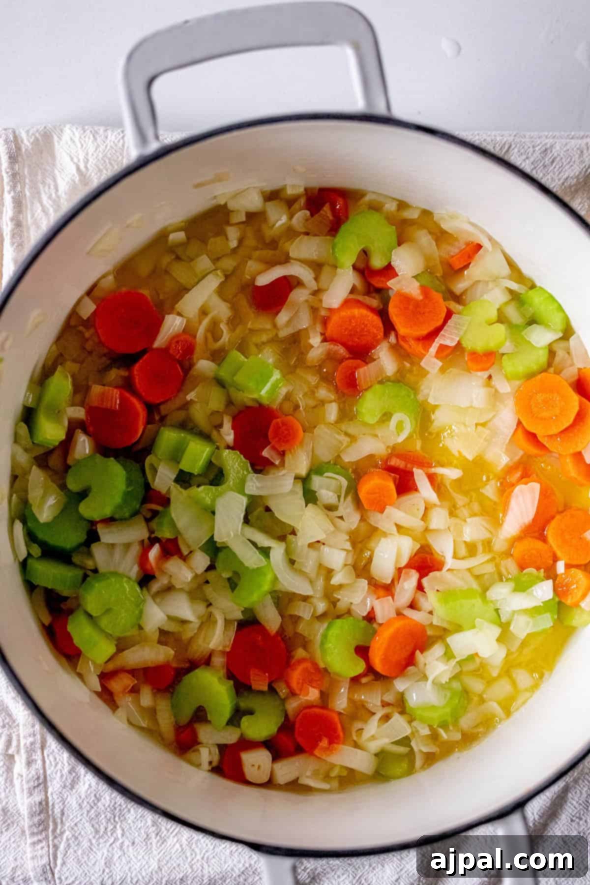 Easy 15-Minute One-Pot Potsticker Soup 7 A pot with chopped carrots, celery, and onions simmering in oil forms the perfect base for a quick 15-minute potsticker soup.