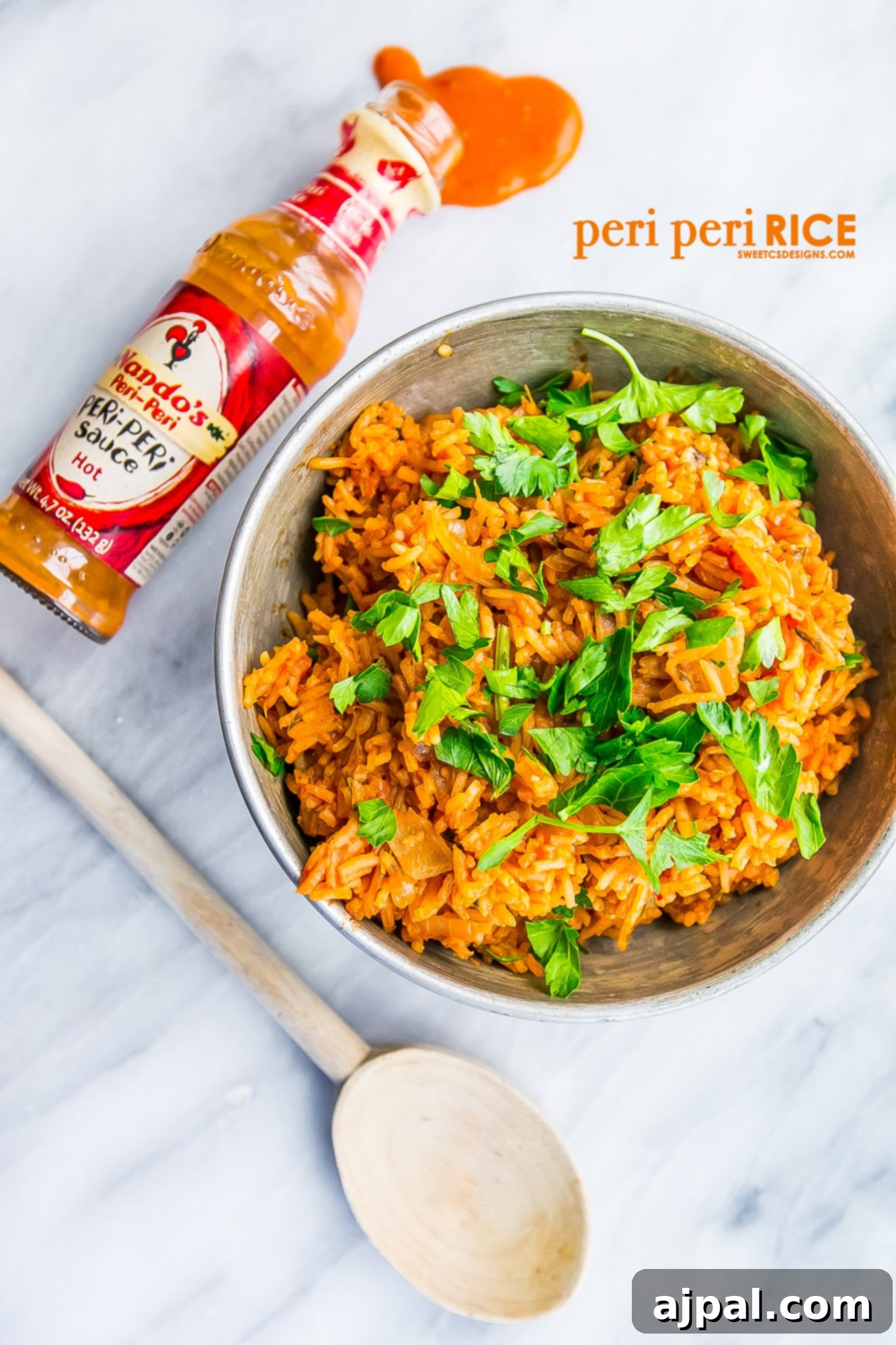 A close-up of flavorful Portuguese-inspired rice garnished with fresh herbs, alongside a bottle of spicy peri-peri sauce.
