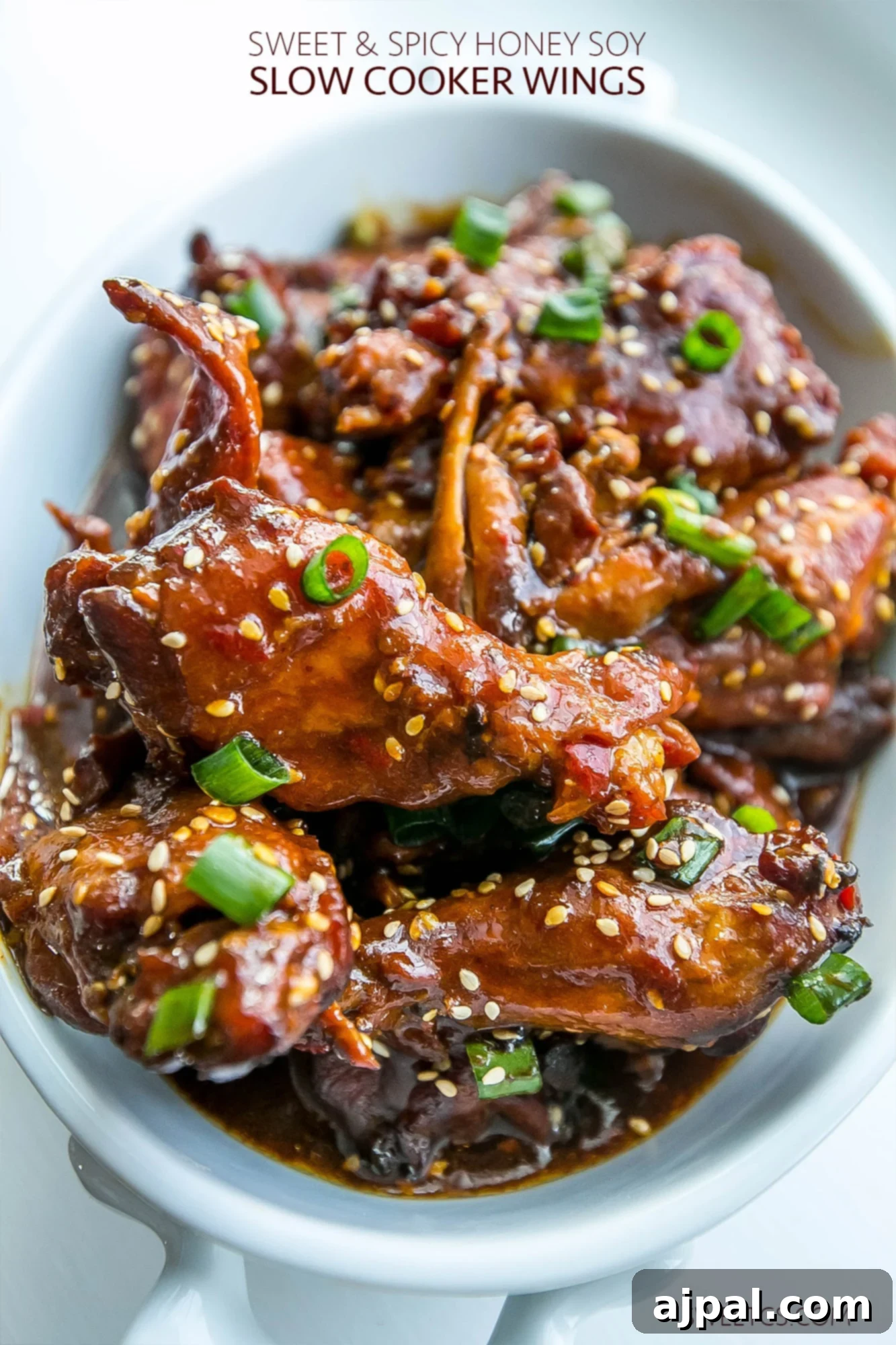 Sticky Honey Soy Slow Cooker Chicken Wings 7 Sweet and spicy honey soy chicken wings in a white serving dish, garnished and ready.