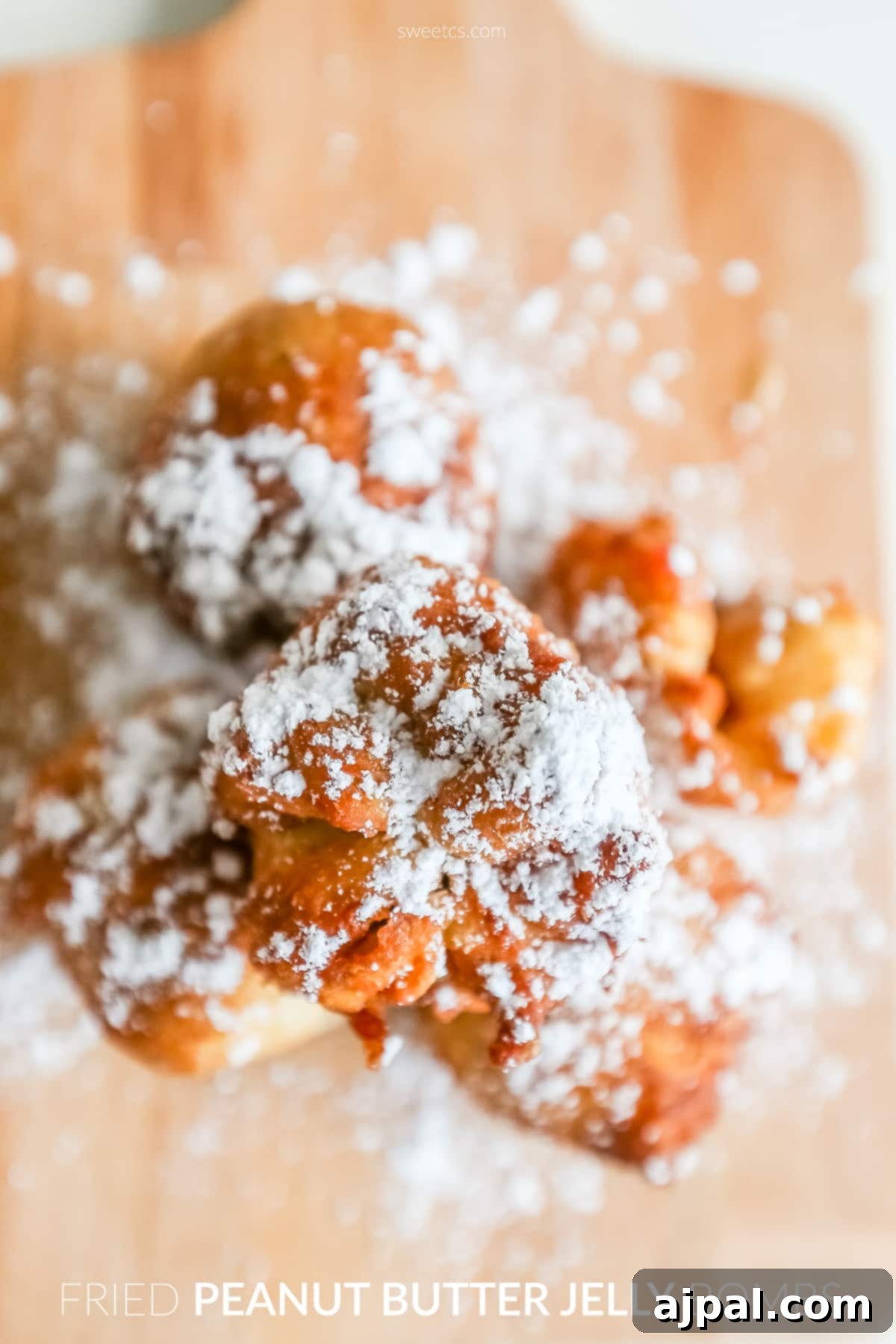 Golden Peanut Butter Jelly Poppers 3 Freshly fried dough with powdered sugar, showcasing the irresistible appeal of peanut butter jelly bombs.