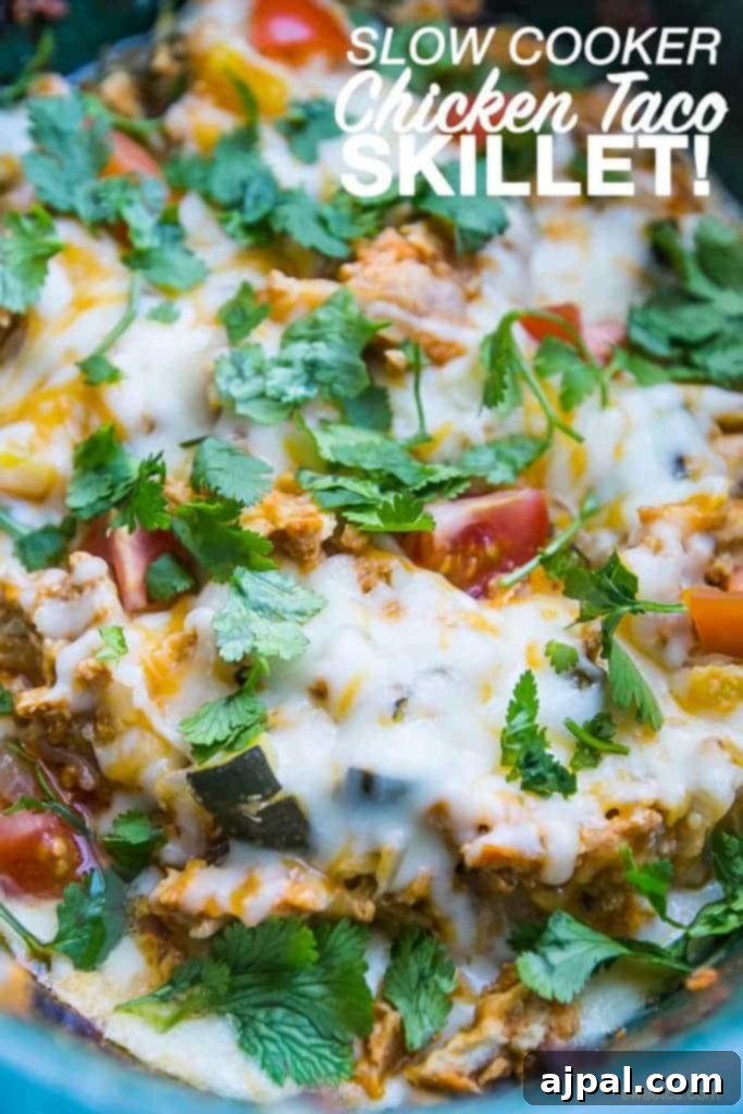 Easy Slow Cooker Chicken Taco Bowls 2 Mouthwatering chicken taco and vegetable mix in a slow cooker, generously topped with melted cheese, ready to be served