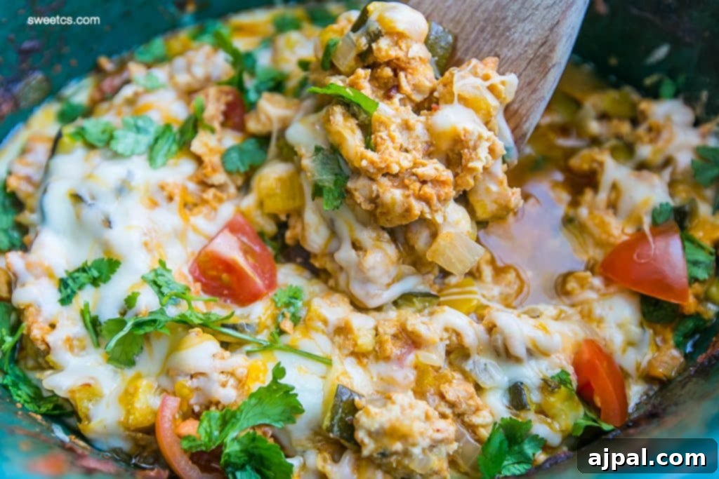 Easy Slow Cooker Chicken Taco Bowls 4 Flavorful chicken and vegetable taco mixture simmering in a slow cooker, topped with bubbly, melted cheese