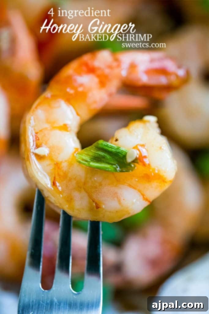 Succulent honey ginger baked shrimp on a fork, garnished with fresh chives, ready to be enjoyed as a gourmet appetizer.