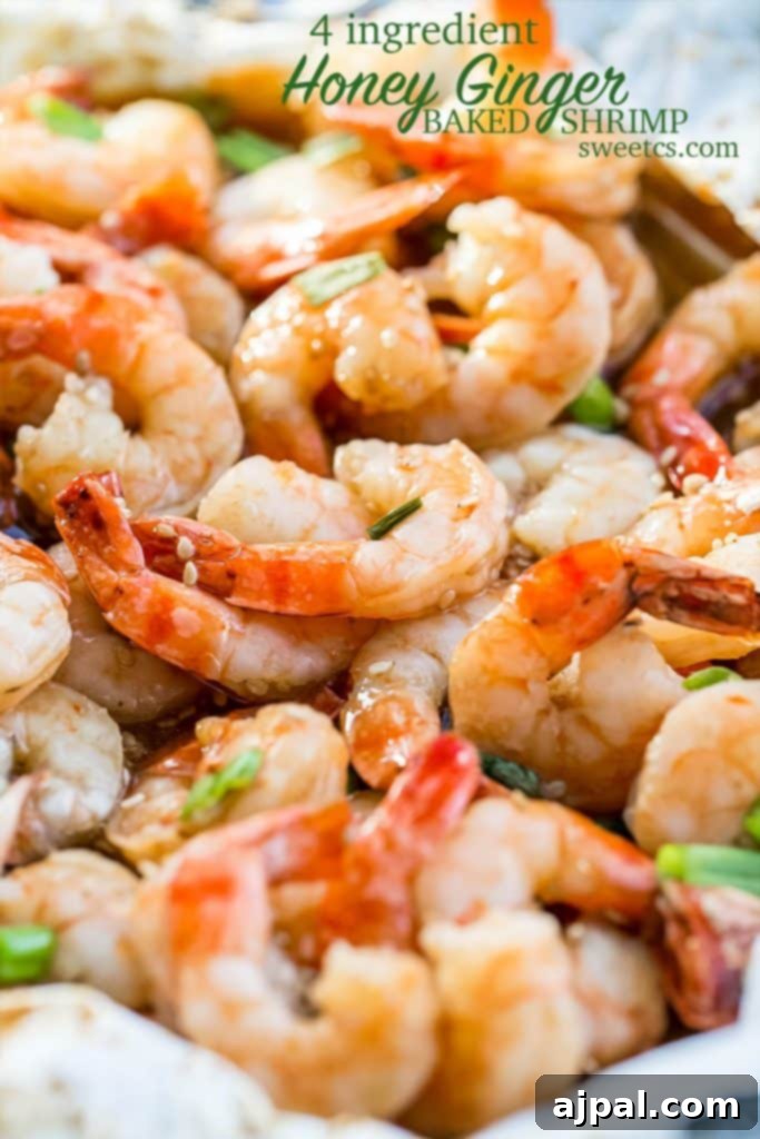 A white dish holding four ingredient honey ginger baked shrimp, beautifully garnished with fresh green onions and sesame seeds, highlighting the dish's irresistible appeal.