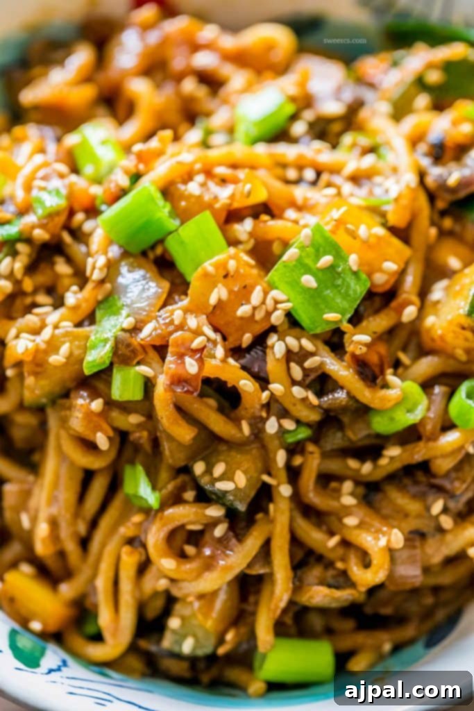 Velvety Tahini Noodles 3 A vibrant bowl of vegan tahini noodles with colorful stir-fried vegetables and toasted sesame seeds.