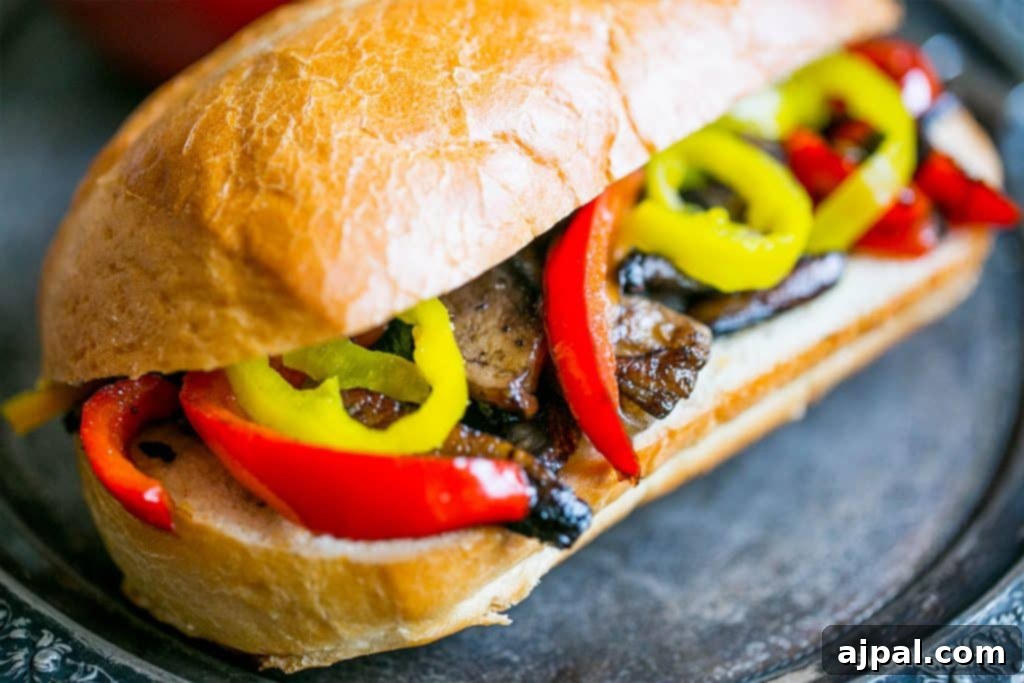 A vibrant vegan hoagie featuring sautéed bell peppers and mushrooms, served on a plate and ready to be enjoyed.