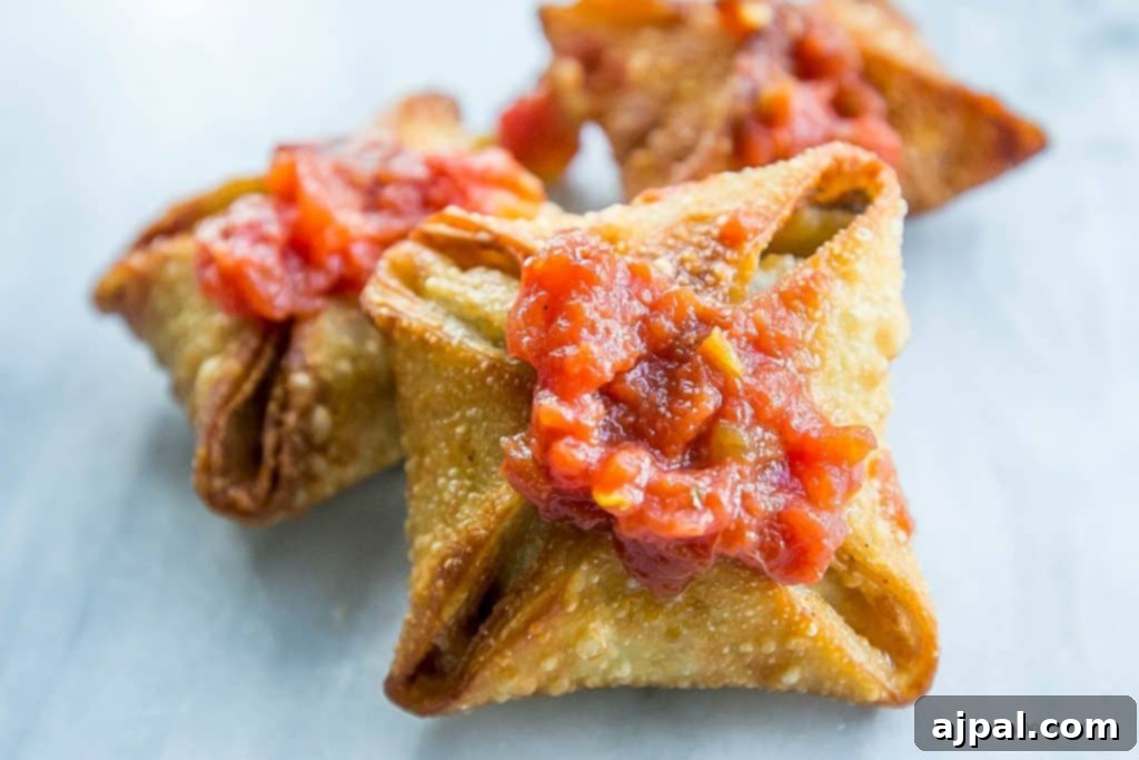 Kickin' Vegan Samosas 2 Crispy vegan samosas with a vibrant red chutney on a pristine white surface, highlighting their spicy and meaty flavor.