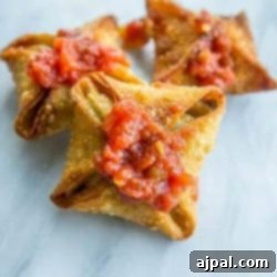 Kickin' Vegan Samosas 8 Star-shaped vegan samosas, artfully arranged and drizzled with tomato sauce on a elegant marble table.