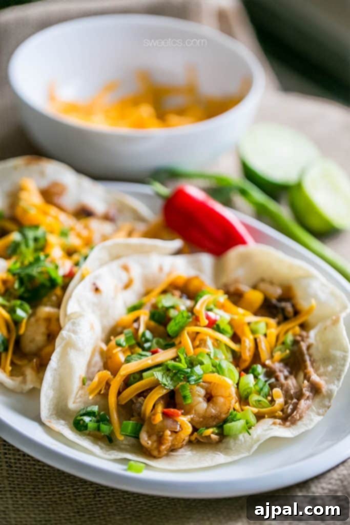 Zesty Old Bay Shrimp Fajita Tacos 2 Two shrimp tacos on a plate with limes and cilantro.