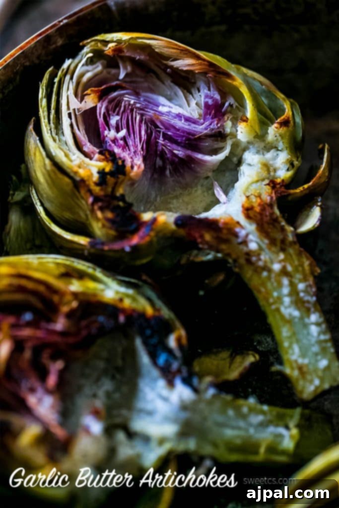 Multiple halves of perfectly charred artichokes arranged on a rustic platter, glistening with garlic butter and herbs, ready for a gourmet meal.